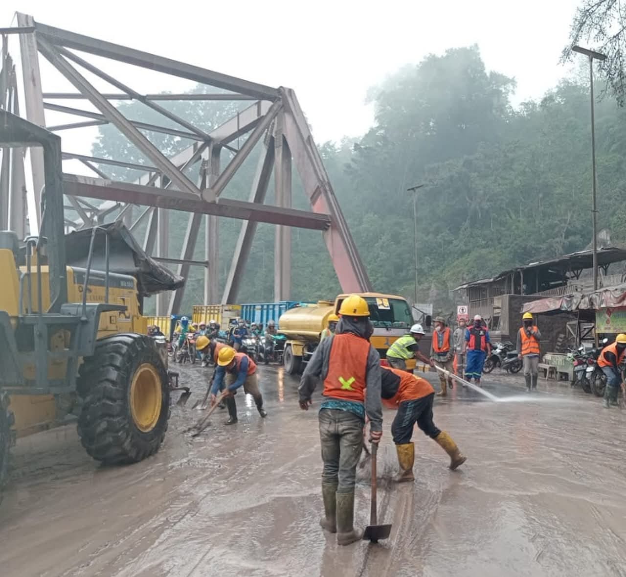 Petugas membersihkan debu di jembatan perak karena licin membahayakan (Foto BPBD Lumajang)