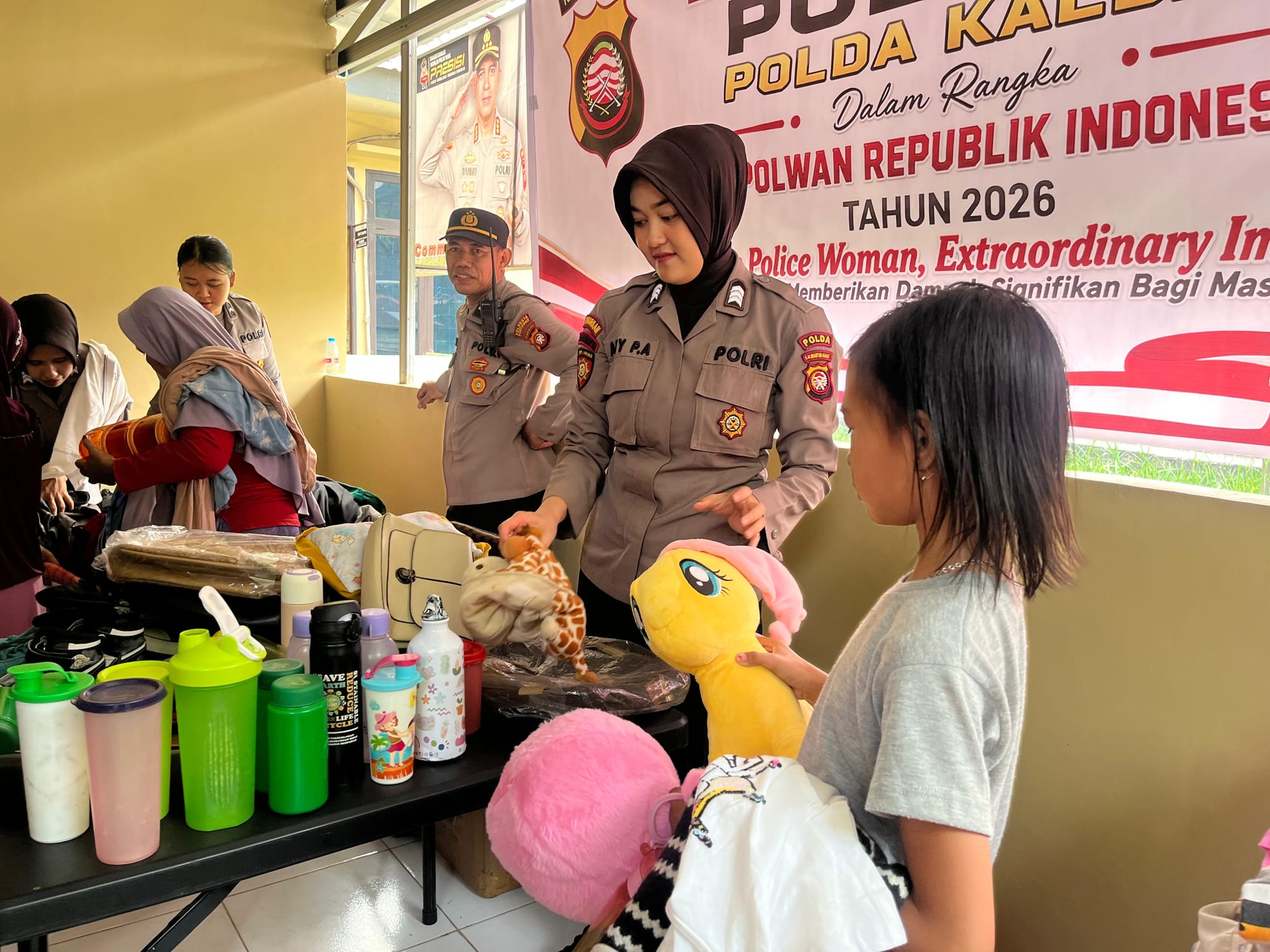 Anggota polwan sedang melayani seorang anak kecil yg juta datang di tempat kegtanan. Foto: Spektroom