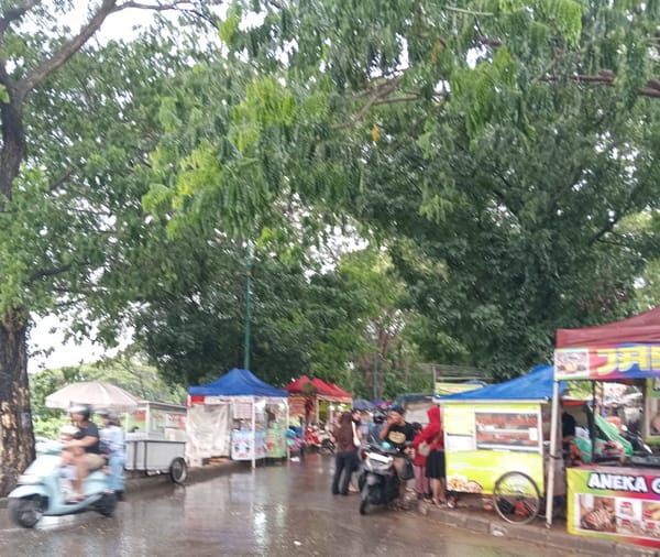 "Omzet  vs Hujan:  Perjuangan PKL Malam Tahun Baru"