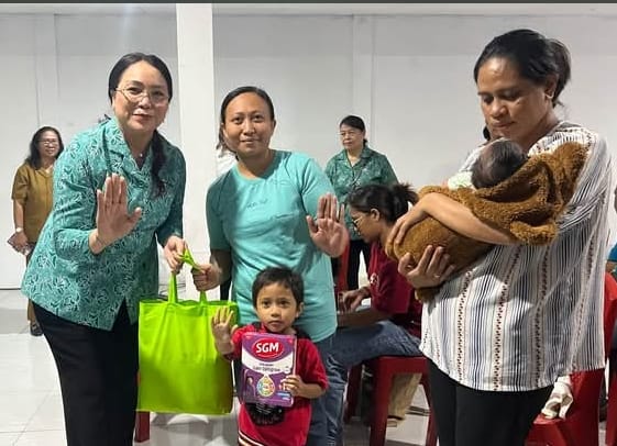 Ketua Tim Penggerak PKK Kota Ambon, Lisa Wattimena,menyerahkan bantuan kepada balita katagori stunting.